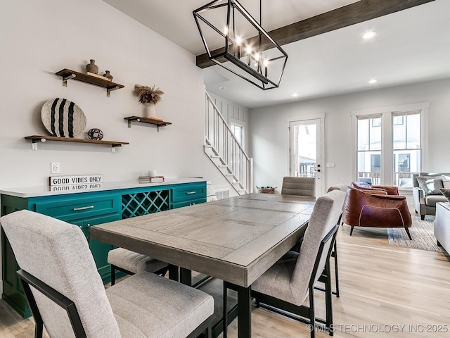 dining room with beamed ceiling, a notable chandelier, light wood-style flooring, recessed lighting, and stairs