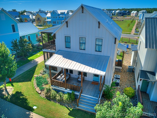 view of front facade featuring a balcony, cooling unit, a porch, a residential view, and board and batten siding