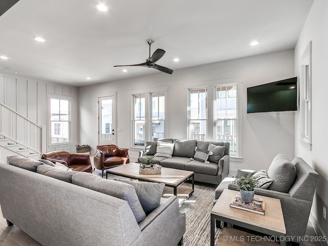 living area with stairway, recessed lighting, a ceiling fan, and a wealth of natural light