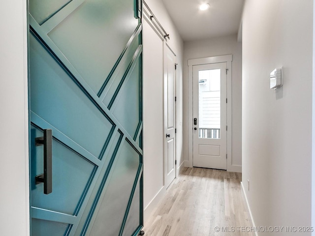 entryway with baseboards and light wood-style floors