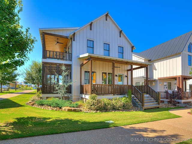 view of front of home with a front yard, a balcony, covered porch, ceiling fan, and board and batten siding