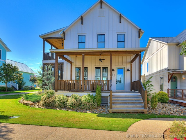 view of front facade with covered porch, board and batten siding, and a front yard