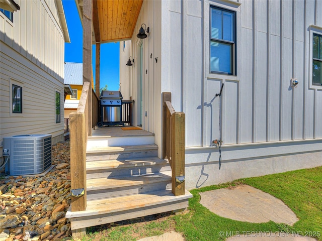 entrance to property featuring cooling unit and board and batten siding