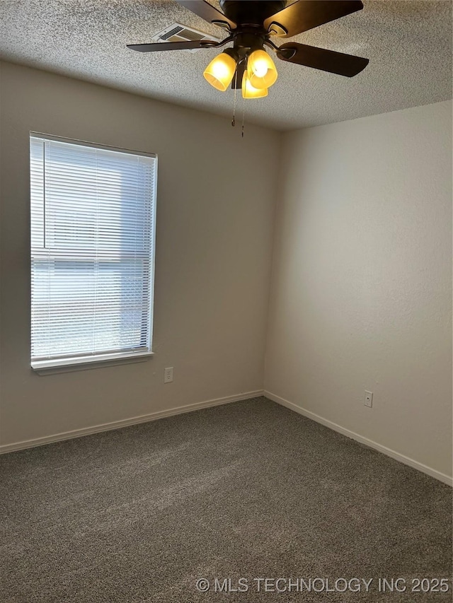 carpeted empty room featuring baseboards, a healthy amount of sunlight, a textured ceiling, and ceiling fan