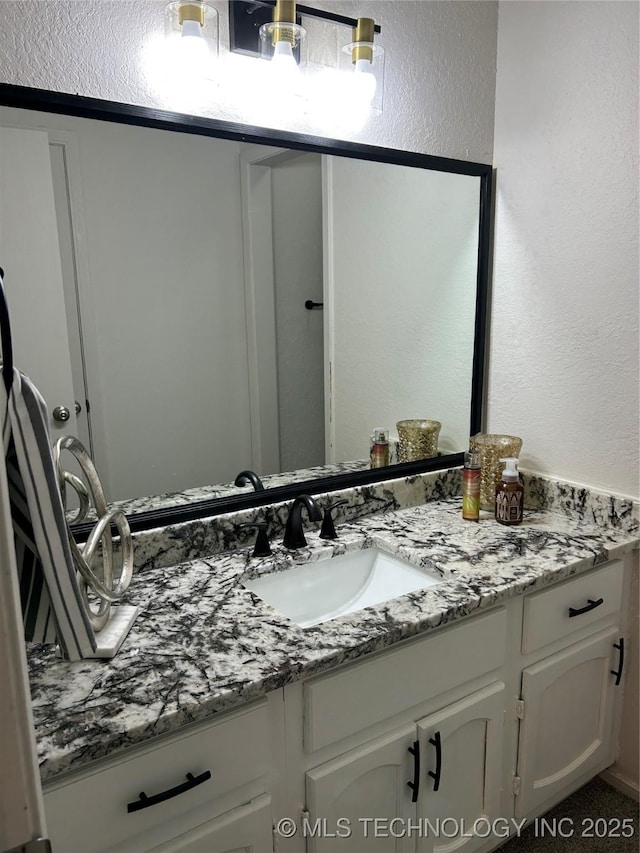 bathroom featuring vanity and a textured wall