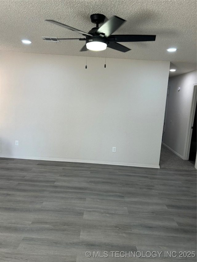 unfurnished room featuring visible vents, a textured ceiling, wood finished floors, baseboards, and ceiling fan