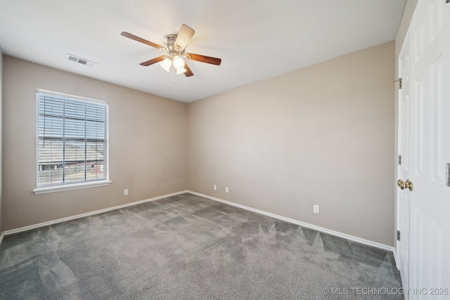 carpeted spare room featuring baseboards, visible vents, and ceiling fan