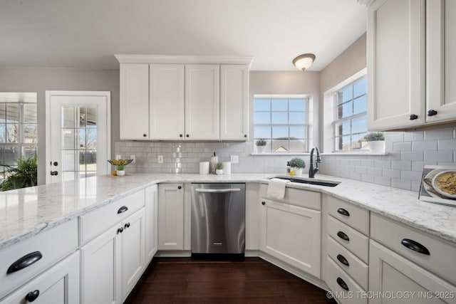 kitchen with backsplash, dishwasher, white cabinetry, and a sink