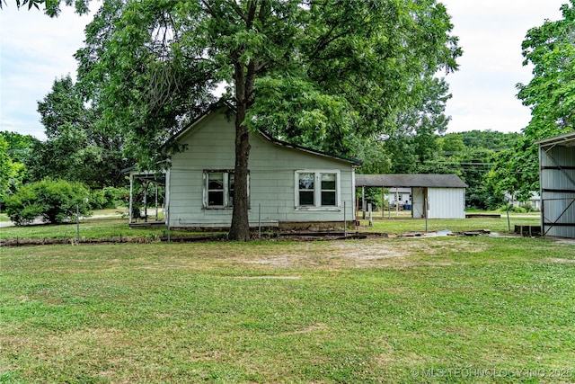 rear view of house with a carport and a lawn