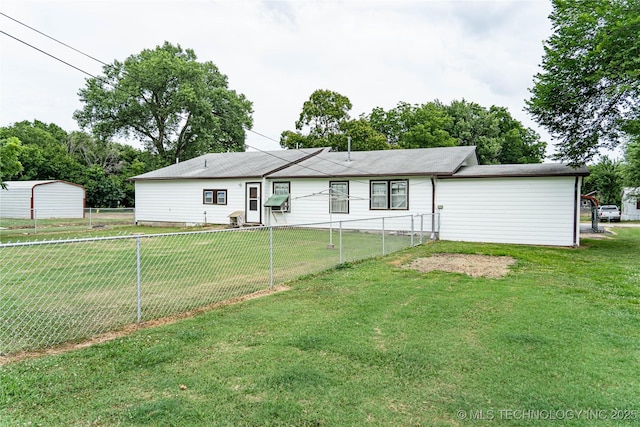 back of house featuring a lawn and fence