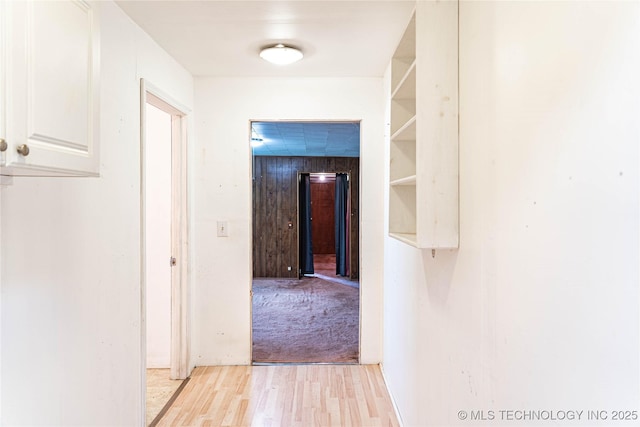 hall with light carpet and light wood-style flooring