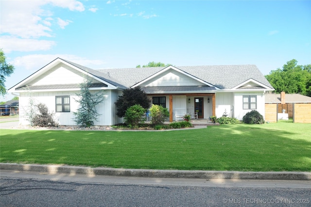 ranch-style house with a standing seam roof, covered porch, a front lawn, board and batten siding, and metal roof