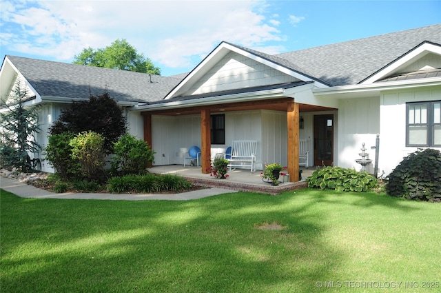 view of front of home featuring a front lawn, roof with shingles, covered porch, and board and batten siding
