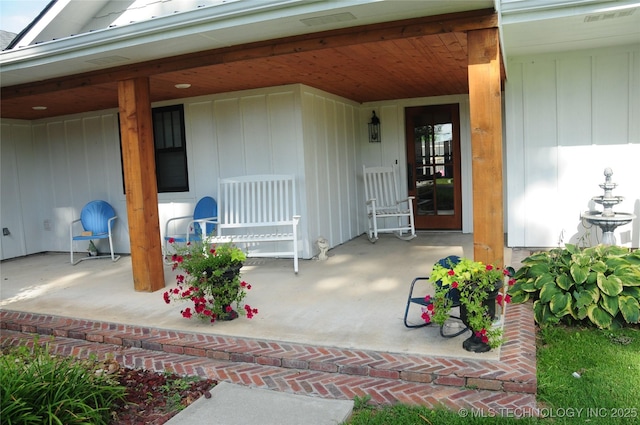 doorway to property featuring a porch, board and batten siding, and visible vents