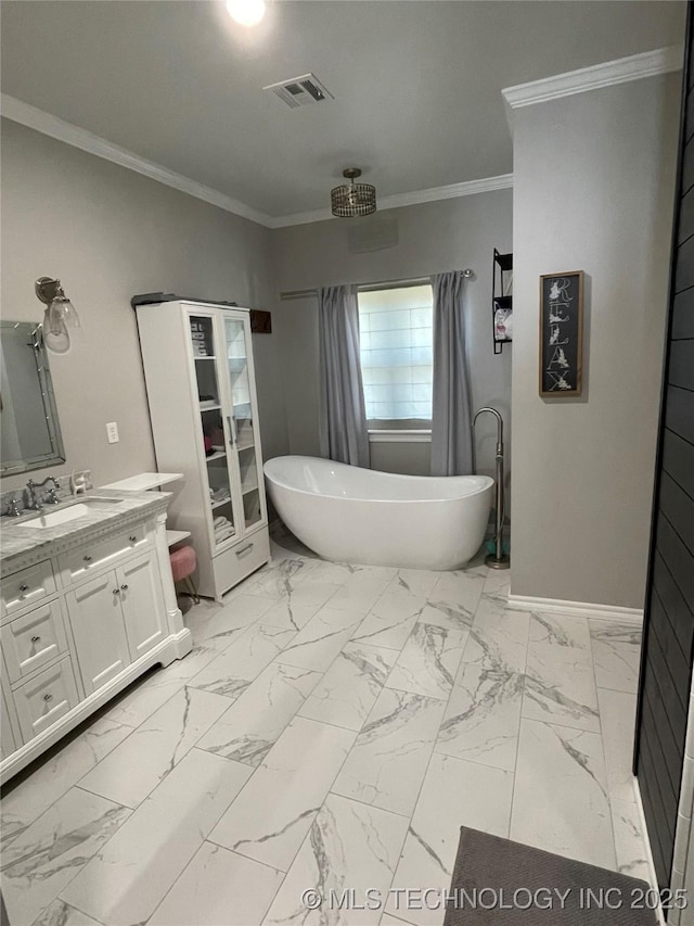 full bath with crown molding, vanity, marble finish floor, visible vents, and a soaking tub