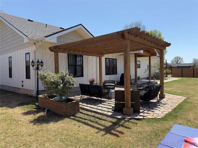 rear view of property featuring a lawn, a pergola, a shingled roof, and a patio