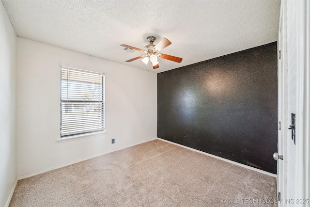 spare room with baseboards, a textured ceiling, ceiling fan, and carpet flooring