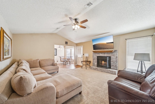 living room with a ceiling fan, visible vents, carpet floors, a fireplace, and vaulted ceiling