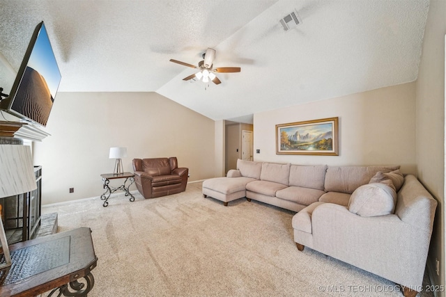 living room with visible vents, a textured ceiling, carpet flooring, lofted ceiling, and ceiling fan