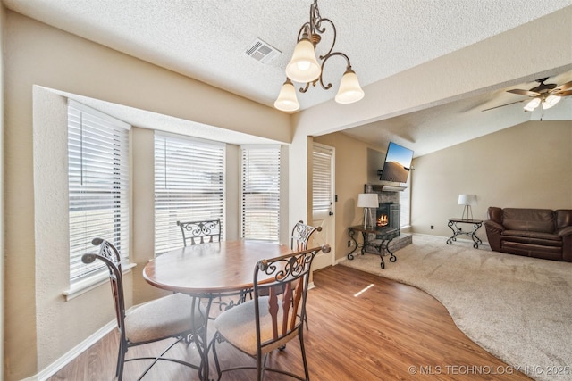 dining area with visible vents, a healthy amount of sunlight, a fireplace, and wood finished floors