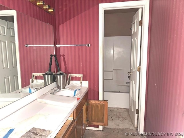 full bath featuring shower / tub combination, vanity, and wallpapered walls