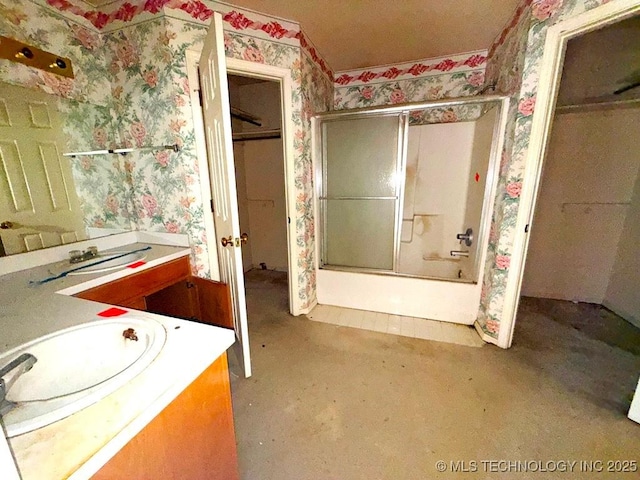 full bath featuring wallpapered walls, vanity, and combined bath / shower with glass door