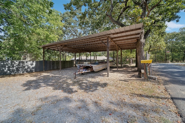 view of parking with a carport and fence