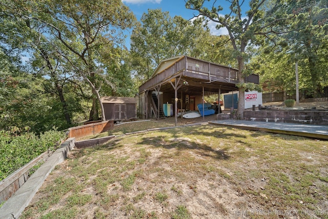 view of yard featuring an outdoor structure, a shed, and a wooden deck