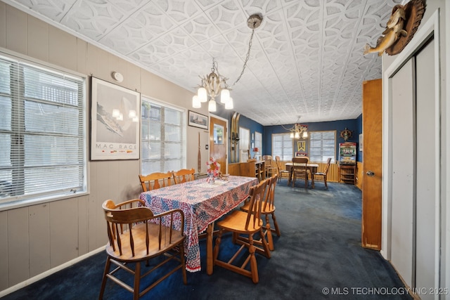 carpeted dining area with an inviting chandelier and an ornate ceiling