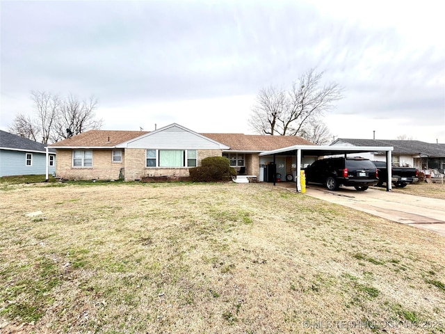 ranch-style home with a front lawn, an attached carport, concrete driveway, a shingled roof, and brick siding