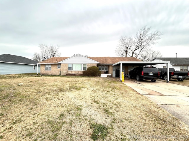 ranch-style home with brick siding, an attached carport, a front lawn, and driveway