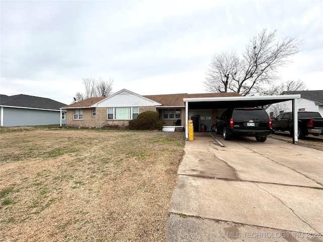 single story home featuring a front lawn, a carport, and driveway