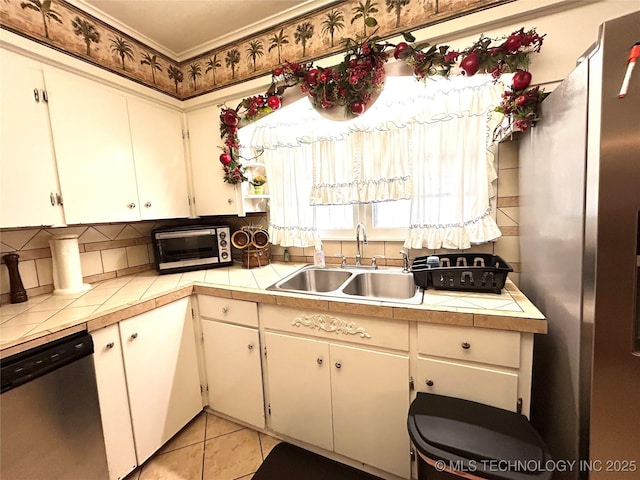 kitchen with tile countertops, a toaster, light tile patterned flooring, a sink, and stainless steel appliances