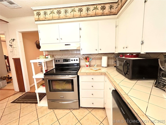 kitchen featuring visible vents, under cabinet range hood, stainless steel appliances, light tile patterned floors, and tile counters