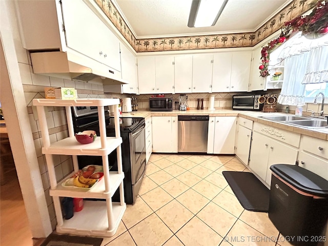 kitchen featuring a sink, stainless steel appliances, decorative backsplash, and open shelves