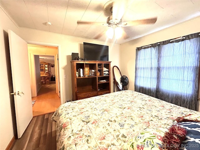 bedroom with ceiling fan, dark wood-style flooring, and crown molding