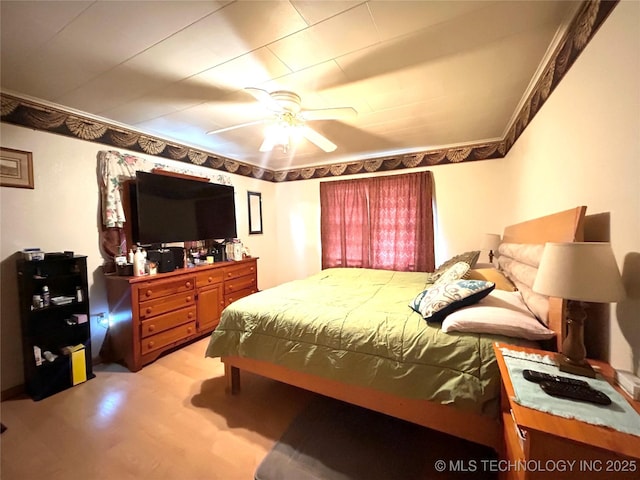 bedroom featuring light wood-style flooring, ceiling fan, and crown molding