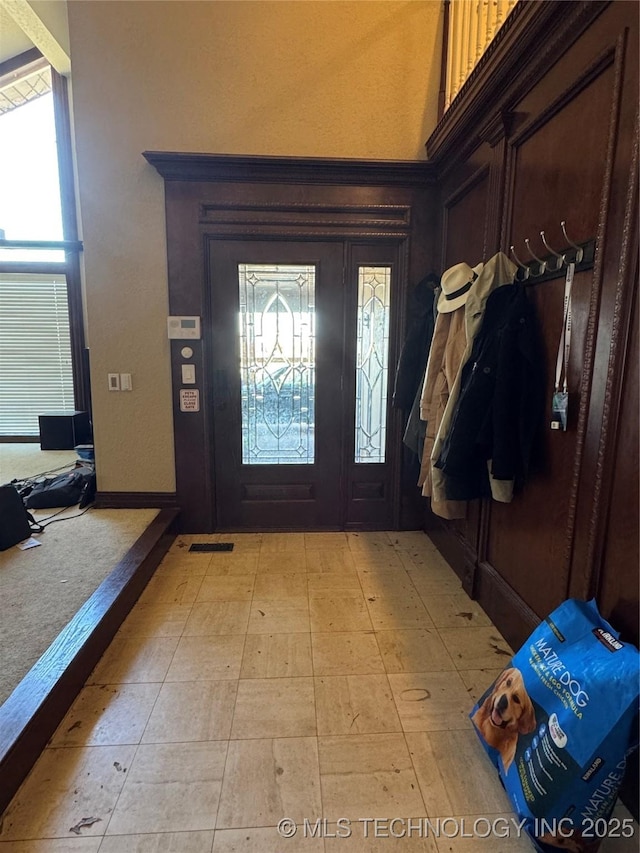 foyer featuring visible vents and a towering ceiling