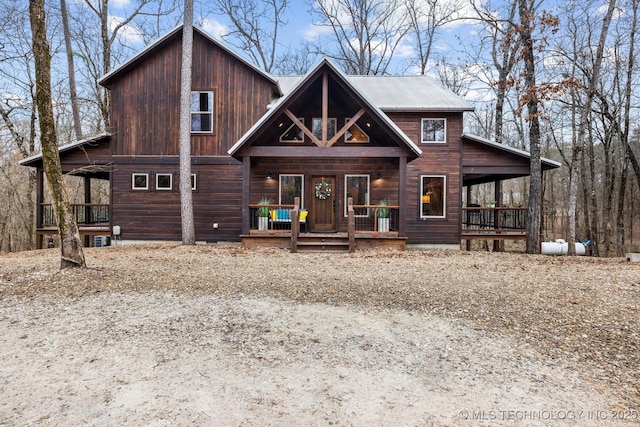 rustic home featuring a porch and metal roof