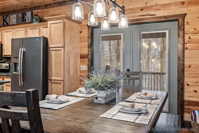 dining room with an inviting chandelier and wooden walls