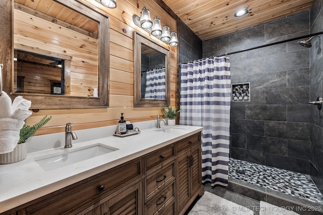 bathroom featuring double vanity, wood ceiling, tiled shower, and a sink