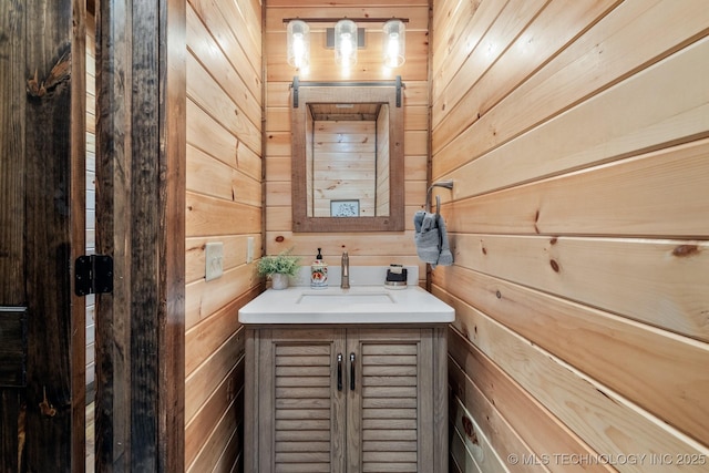 bathroom featuring vanity and wood walls