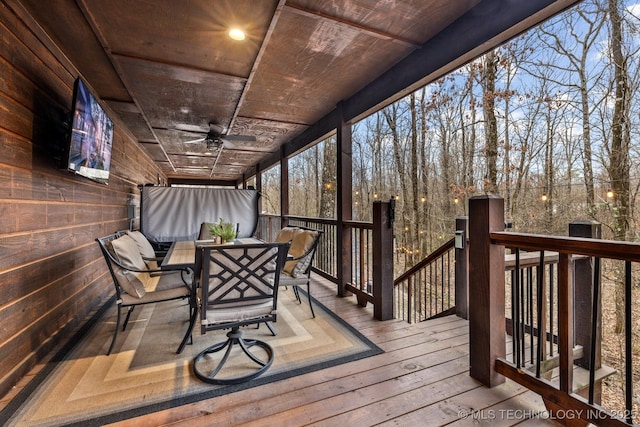 deck with outdoor dining area and a ceiling fan