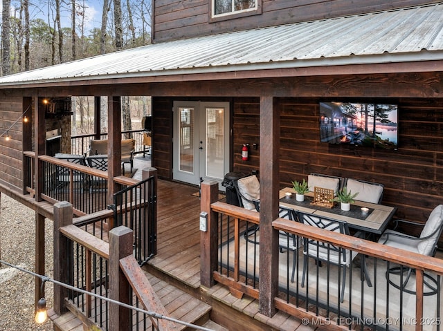 wooden deck featuring outdoor dining area and french doors