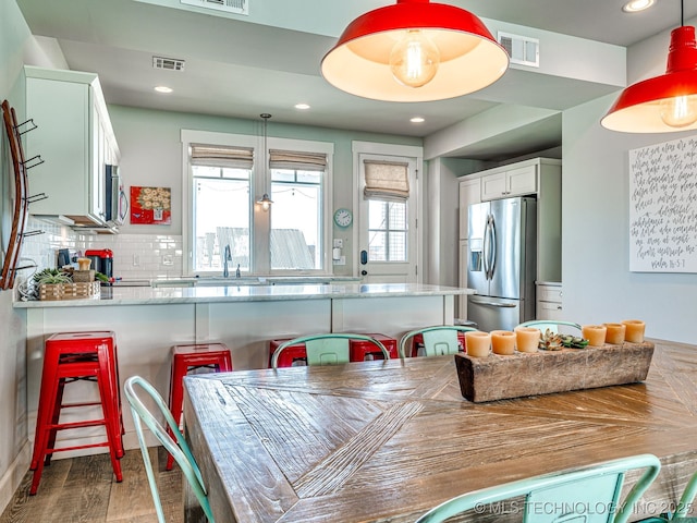 dining space featuring wood finished floors and recessed lighting