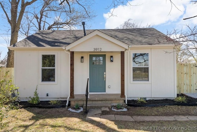 view of front of house with fence and roof with shingles