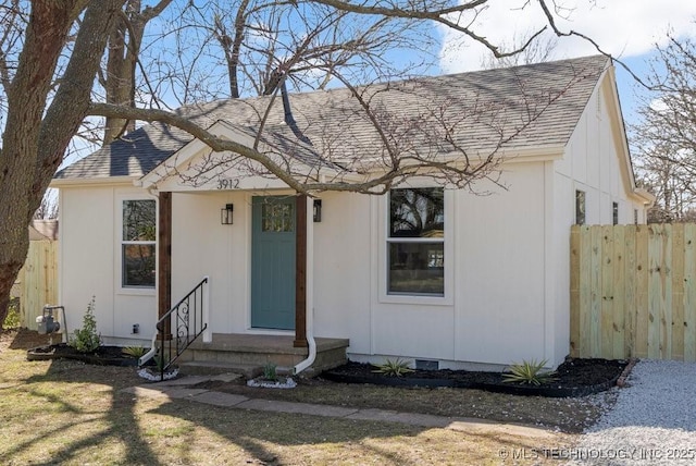 view of front of property with fence, roof with shingles, and crawl space