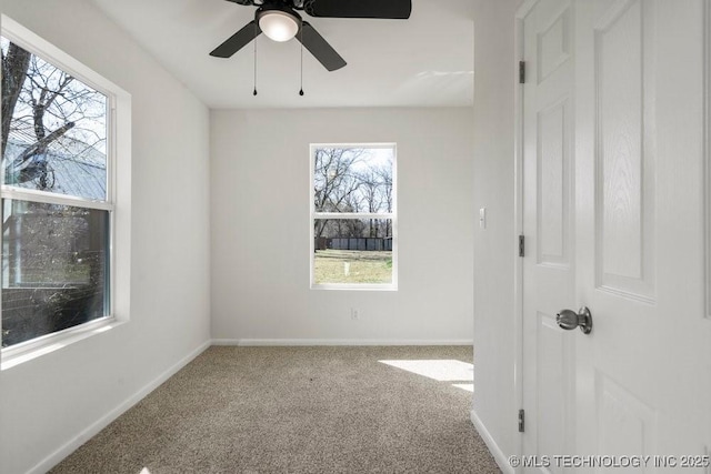 spare room with baseboards, carpet, and a ceiling fan