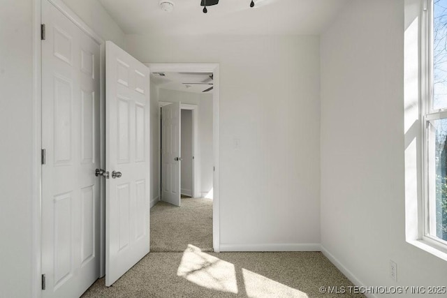 unfurnished bedroom with light colored carpet and baseboards