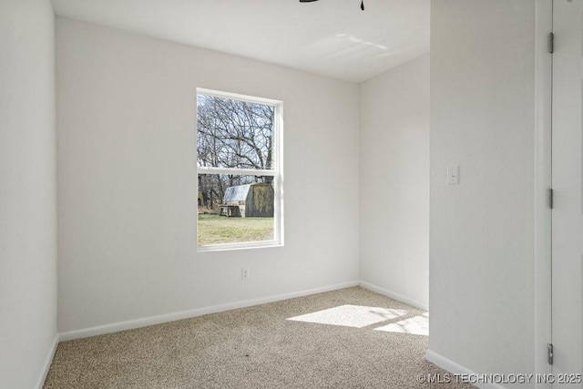 carpeted spare room featuring baseboards, a healthy amount of sunlight, and a ceiling fan